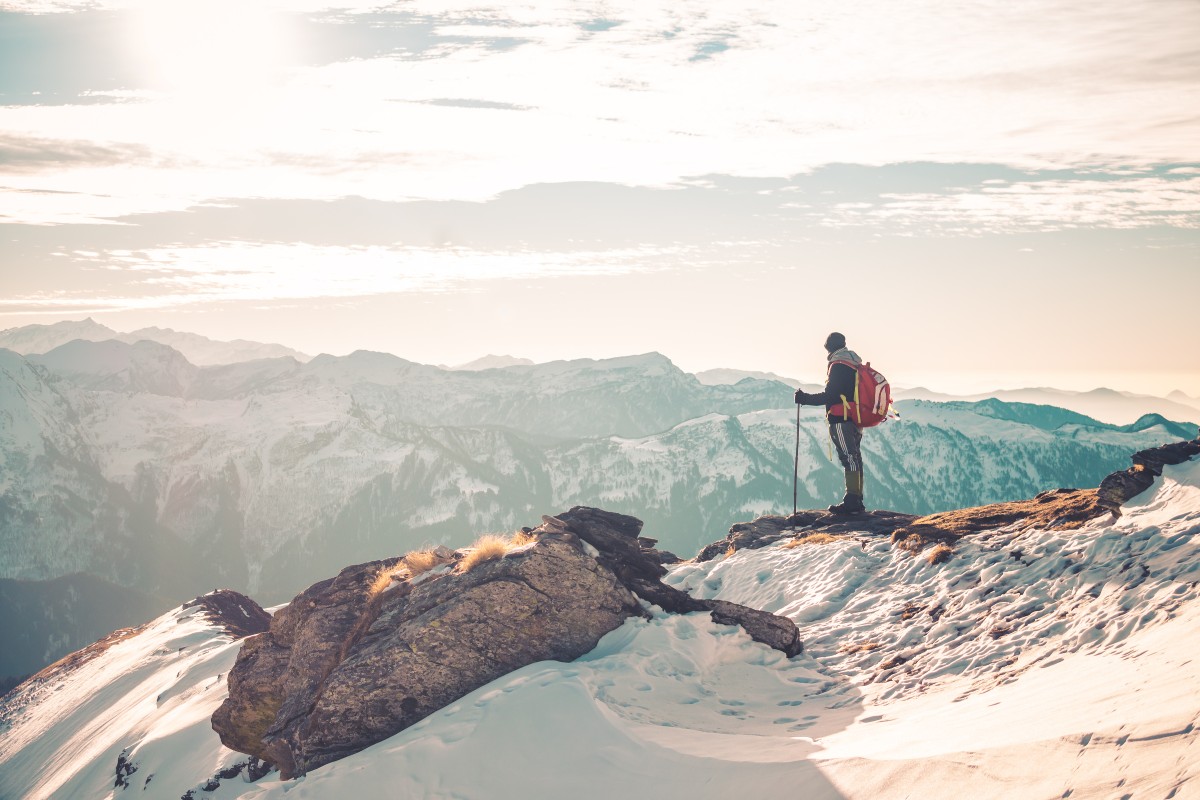 man standing on top of snow covered mountain